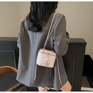 Mini pink quilted box bag with diamond embellishments and chain strap shown on model