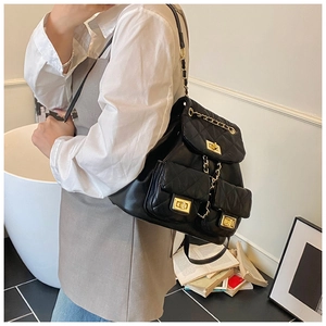 Detail shot of black quilted leather backpack with gold chain and turn-lock pockets