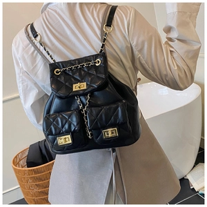 Quilted black leather backpack with gold chain straps shown on a model's back