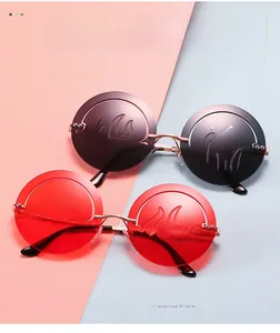 Détail de lunettes de soleil rondes sans monture avec verres flamme en rouge et marron