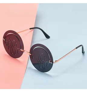 Détail de lunettes de soleil en métal or rose avec verres ronds à motif de flammes