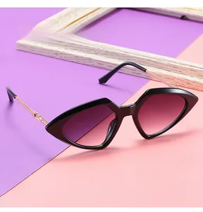 Detail view of cat-eye sunglasses with gold metal temples and purple gradient lenses