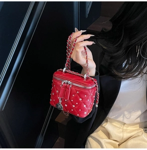 Detail of red quilted mini box bag with sparkling crystals and a rose charm chain