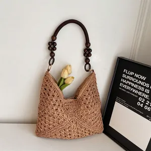 Handwoven straw beach bag with hollow pattern and wooden bead handle for summer vacation