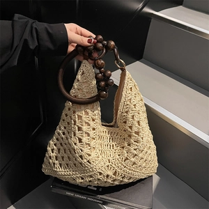 Beige hollow crochet straw beach bag with dark brown wooden bead ring handle for summer