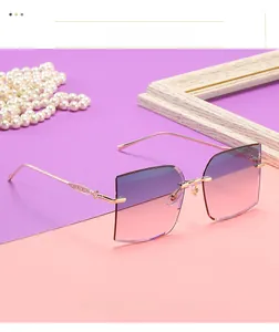 Detail of rimless square sunglasses featuring gradient lenses and gold textured metal temples