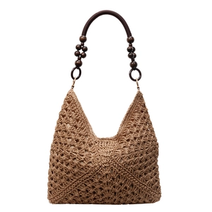 Handmade raffia beach bag with hollow weave pattern and wooden bead shoulder strap