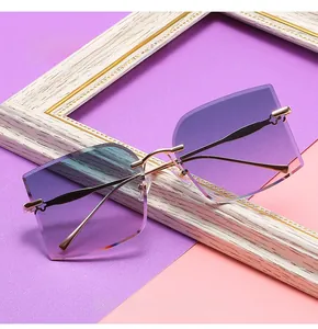 Detail of gradient purple rimless sunglasses with gold floral cutout on metal temples