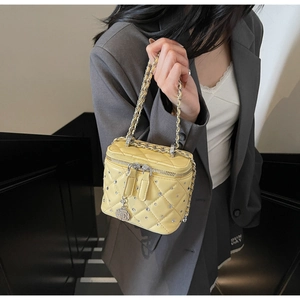 Detail of yellow quilted bag with crystal embellishments and rose chain pendant