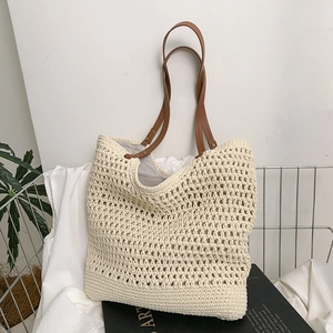 Fashionable beige woven tote bag with brown leather handles and hollow mesh texture