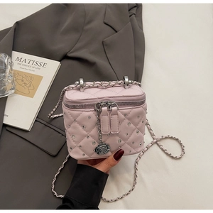 Detail of pink quilted vanity case with rhinestone accents and silver floral charm