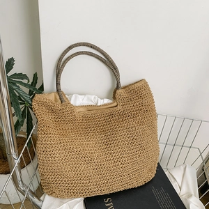 Handwoven straw tote bag with round striped handles for a casual summer holiday style