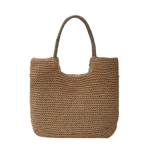 Handmade tan straw shoulder bag with textured U-shape design for summer beach vacation