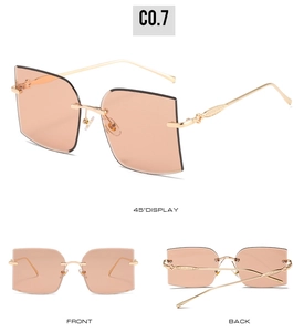 Detailed view of rimless square sunglasses with engraved gold metal temples and brown lenses