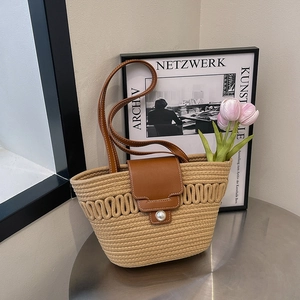 French retro straw bucket bag with brown leather flap and pearl buckle detail