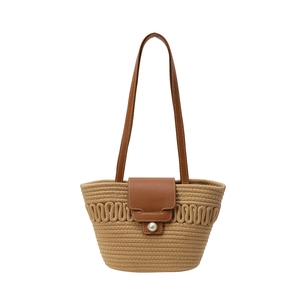 Straw woven shoulder bag with brown leather flap and large pearl buckle closure
