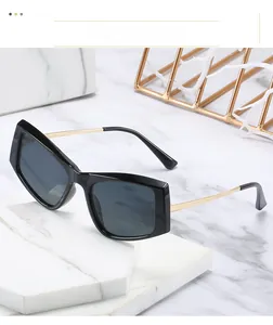 Détail de lunettes de soleil carrées rétro avec monture noire et branches dorées