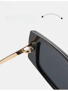 Détail de la charnière en métal doré durable sur la monture de lunettes de soleil carrée