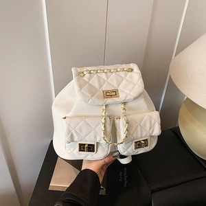 Quilted white backpack with gold chain straps and turn-lock closure in lifestyle setting