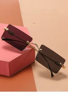 Detail of square rimless sunglasses with purple gradient lenses and gold metal temples