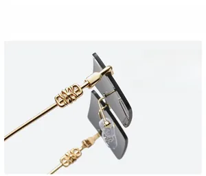 Detailed close-up of golden metal hinges with hollow patterns on square sunglasses