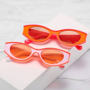 Retro-Cat-Eye-Sonnenbrillen in Orange und Pink auf weißen geometrischen Podesten präsentiert