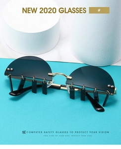 Close-up of retro semi-rimless sunglasses with gold accents and hanging black charms