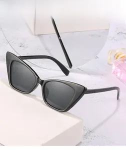Chic black cat-eye sunglasses displayed on white pedestal with perfume and mirror