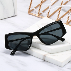 Lunettes de soleil rétro à monture noire épaisse de style œil-de-chat sur marbre