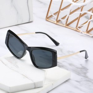 Lunettes de soleil carrées rétro avec monture noire et branches dorées sur marbre