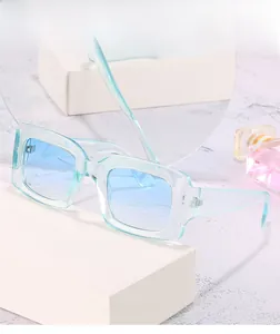 Close-up of retro square sunglasses with transparent light blue frames and gradient lenses