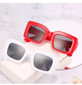 Detailed view of red and white square sunglasses featuring thick frames and gradient lenses