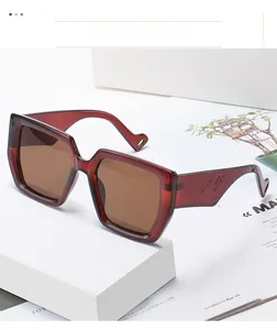 Detail view of burgundy oversized square sunglasses with brown lenses and thick temples
