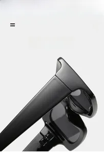 Detail of square black sunglasses showing light high-gloss frame and flexible hinge
