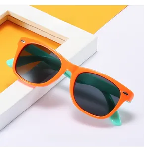 Detailed view of kids' polarized sunglasses with orange frame and mint green temple arms