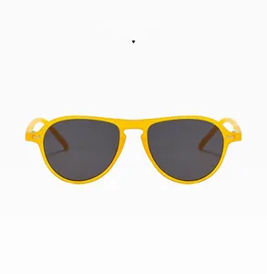 Detail of jelly yellow aviator sunglasses with metal rivets and smoke grey lenses