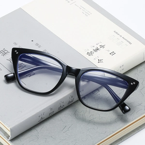 Retro black cat eye blue light blocking glasses with silver rivet accents on books