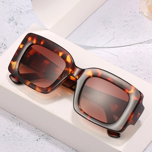 Retro oversized square tortoiseshell sunglasses with brown gradient lenses on marble