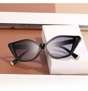 Detail of cat-eye sunglasses with black geometric frame and gradient purple lenses