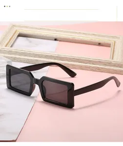 Macro view of wide-rimmed black rectangular sunglasses with vintage glossy frames