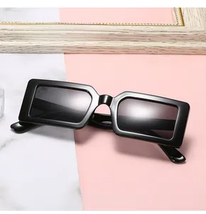 Modern thick black rectangular frame sunglasses with dark lenses on marble background
