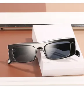 Detail of square black sunglasses with hollowed-out temple design on a geometric block
