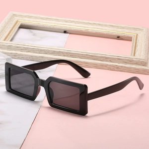 Fashionable black square sunglasses with thick frames on marble background