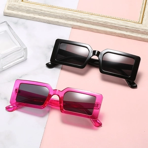 Chic rectangle sunglasses in black and pink frames displayed on a marble background