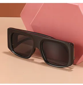Flat top large frame black sunglasses with UV400 lenses on a pink display block