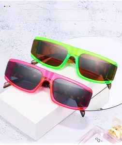 Dettaglio occhiali da sole oversize colorati con aste tartarugate su display geometrico