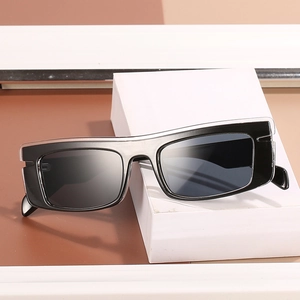 Fashionable black rectangular sunglasses with grey lenses on a white geometric stand