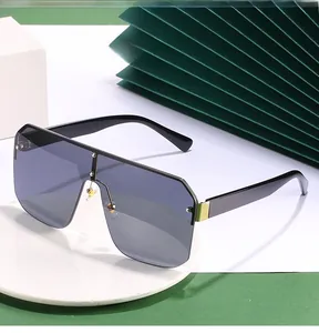 Detail of oversized shield sunglasses with gold metal accents on black thick frames