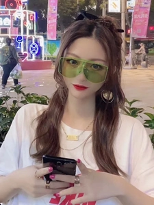 Occhiali da sole oversize verde fluorescente indossati da una modella in stile street