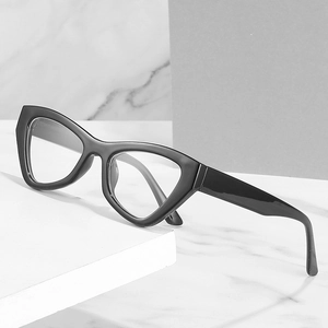 Retro black cat-eye eyeglass frames with transparent lenses on white marble background